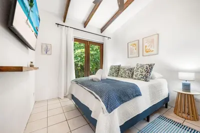a bedroom with a bed and a window at PdM6 Newly Renovated Townhome Steps to the Beach in Tamarindo