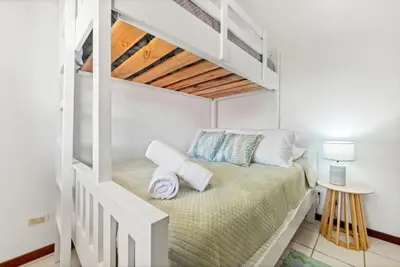 a white room with a bed in a loft at PdM6 Newly Renovated Townhome Steps to the Beach in Tamarindo