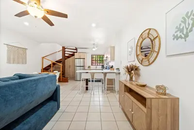 a living room with a blue couch and a table at PdM6 Newly Renovated Townhome Steps to the Beach in Tamarindo
