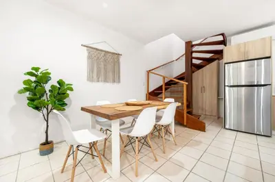 a dining room with a table and white chairs at PdM6 Newly Renovated Townhome Steps to the Beach in Tamarindo