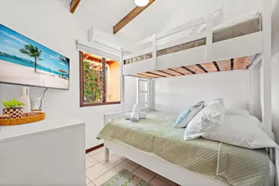 a white bedroom with a bed and a window at PdM6 Newly Renovated Townhome Steps to the Beach in Tamarindo