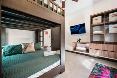 a bedroom with a loft bed with green bedding at CU21 Stylish 5BR Home with Pool and Casita Close to Beach in Tamarindo