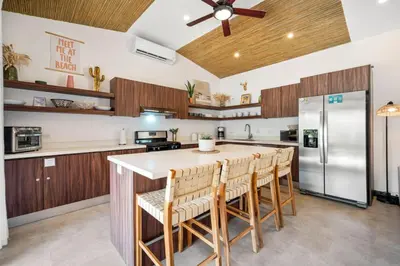 a kitchen with a large island with bar stools at CU21 Stylish 5BR Home with Pool and Casita Close to Beach in Tamarindo