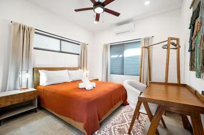 a bedroom with a bed and a desk and a window at CU21 Stylish 5BR Home with Pool and Casita Close to Beach in Tamarindo