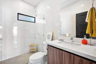 a white bathroom with a toilet and a sink at CU21 Stylish 5BR Home with Pool and Casita Close to Beach in Tamarindo