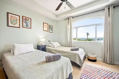 two beds in a room with a window at Ocean View Condo in Tamarindo Steps to the Sand in Tamarindo