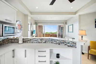 a kitchen with white cabinets and a view of the ocean at Ocean View Condo in Tamarindo Steps to the Sand in Tamarindo