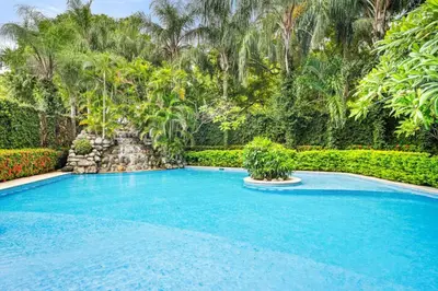 a swimming pool in a yard with trees at Ocean View Condo in Tamarindo Steps to the Sand in Tamarindo