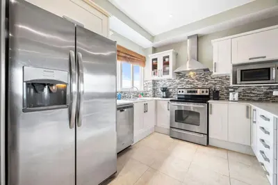 a stainless steel refrigerator in a kitchen with white cabinets at Ocean View Condo in Tamarindo Steps to the Sand in Tamarindo