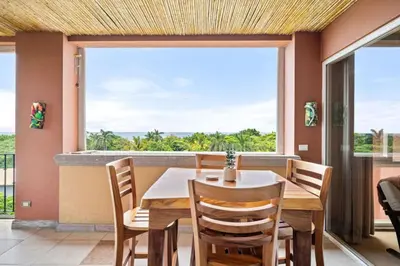 a dining room with a table and chairs and a large window at Ocean View Condo in Tamarindo Steps to the Sand in Tamarindo