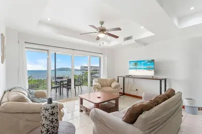 a living room with a ceiling fan and a table at Stunning Ocean-View 2 BD Overlooking Tamarindo in Tamarindo