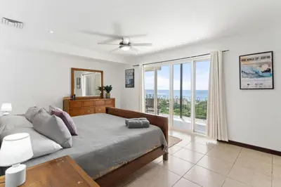 a bedroom with a bed and a large window at Stunning Ocean-View 2 BD Overlooking Tamarindo in Tamarindo