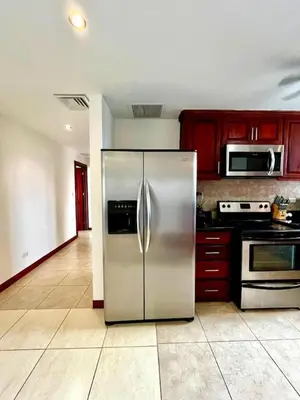 a stainless steel refrigerator in a kitchen with red cabinets at Stunning Ocean-View 2 BD Overlooking Tamarindo in Tamarindo