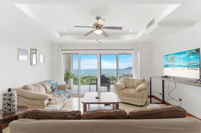 a living room with a couch and a ceiling fan at Stunning Ocean-View 2 BD Overlooking Tamarindo in Tamarindo