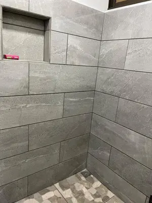a bathroom with a shower with gray tiles at La Casita in San Isidro