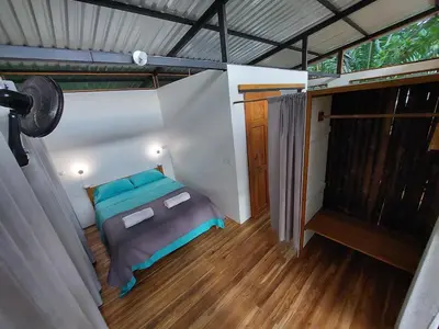 a small room with a bed and a balcony at Jungle Studio in Drake Bay in Drake