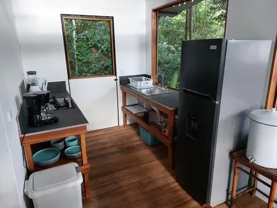 a small kitchen with a refrigerator and a sink at Jungle Studio in Drake Bay in Drake