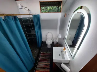 a bathroom with a toilet and a sink and a mirror at Jungle Studio in Drake Bay in Drake