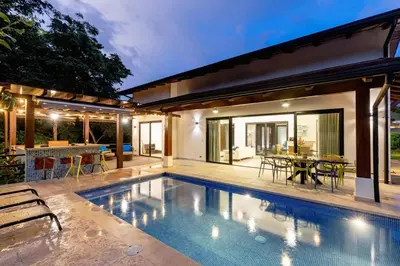 a swimming pool in the backyard of a house at Private Pool Luxury Modern House - Llama del Bosque - Reserva Conchal Golf Resort in Playa Conchal