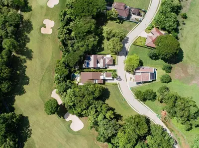 an overhead view of a estate with trees and a road at Private Pool Luxury Modern House - Llama del Bosque - Reserva Conchal Golf Resort in Playa Conchal