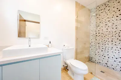 a bathroom with a sink and a toilet and a shower at Private Pool Luxury Modern House - Llama del Bosque - Reserva Conchal Golf Resort in Playa Conchal