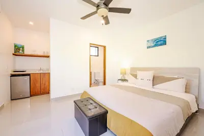 a bedroom with a large bed with a ceiling fan at Private Pool Luxury Modern House - Llama del Bosque - Reserva Conchal Golf Resort in Playa Conchal