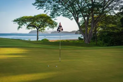 a golf course with a flag on the green at Private Pool Luxury Modern House - Llama del Bosque - Reserva Conchal Golf Resort in Playa Conchal