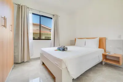a bedroom with a large white bed and a window at Casa Mango - Villaggio 6 in Potrero