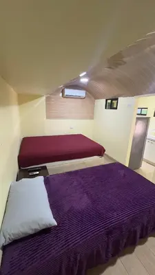 a bedroom with two beds with purple sheets at Casa Antioquia #4 in Garita