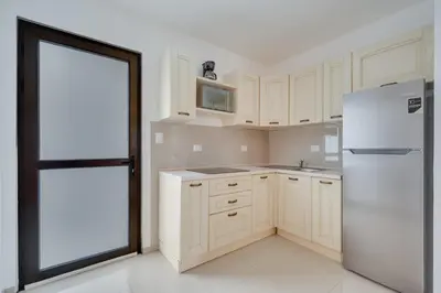 a kitchen with white cabinets and a white refrigerator at Casa Luna - Villaggio 6 in Potrero