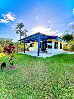 a house with a green lawn in front of it at Nature and Views - 30 min to La Fortuna in Tigra
