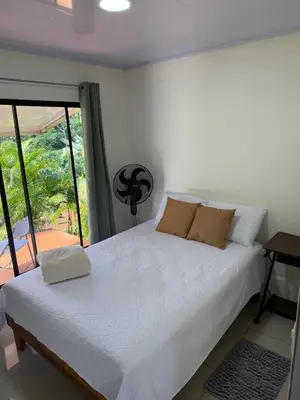 a white bed in a room with a window at Nature and Views - 30 min to La Fortuna in Tigra