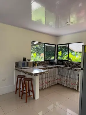 a kitchen with a counter and two windows at Nature and Views - 30 min to La Fortuna in Tigra