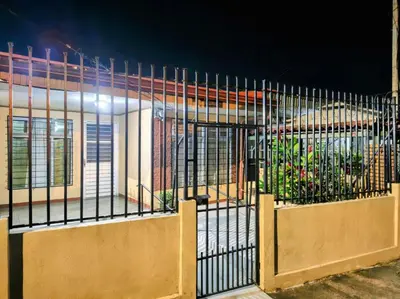 a gate in front of a building at night at Casa Brasil in Alajuela City