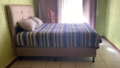 a bed in a room with a window at Casa Brasil in Alajuela City