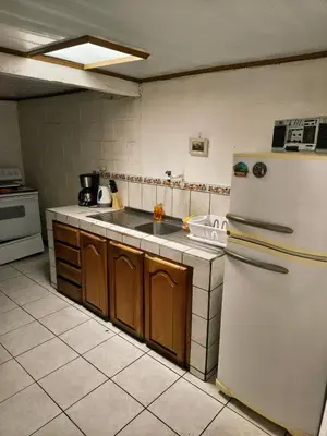 a kitchen with a white refrigerator and a sink at Casa Brasil in Alajuela City