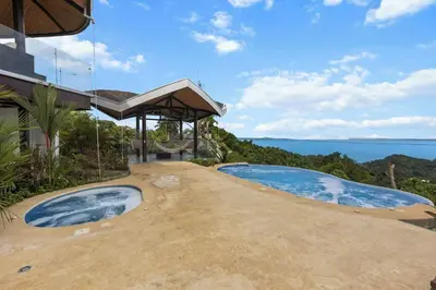 an outdoor swimming pool with a view of the ocean at Breathtaking Views from a Luxury New Villa at Mar a Mar in Jacó