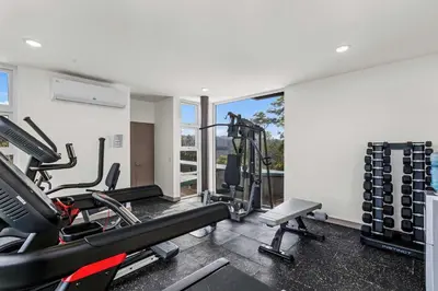 a gym with treadmills and cardio equipment in a room at Breathtaking Views from a Luxury New Villa at Mar a Mar in Jacó