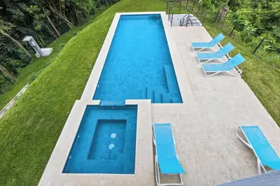 an overhead view of a swimming pool with blue chairs at Breathtaking Views from a Luxury New Villa at Mar a Mar in Jacó