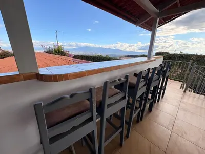 a row of chairs on a balcony with a view at Hotel Honey Bee in Alajuela City