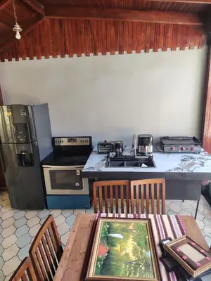 a kitchen with a wooden table with chairs and a stove at Hostal Canarias in San José