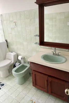a bathroom with a sink and a toilet and a mirror at Hostal Canarias in San José