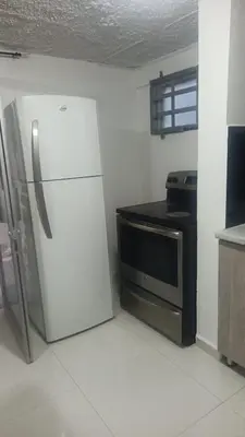 a kitchen with a refrigerator and a microwave at Cerca estadio Nacional in San José