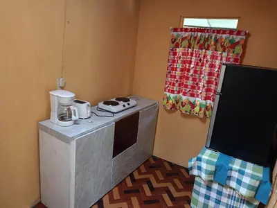 a small kitchen with a counter and a window at The Johnson's Village in Madre de Dios