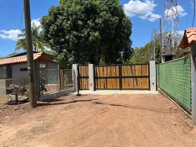 a fence with a wooden gate in front of a house at Accommodation in Tamarindo in Garita