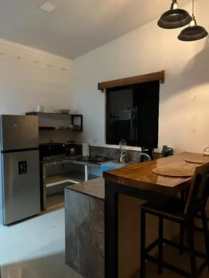 a kitchen with a table and a counter top at Accommodation in Tamarindo in Garita