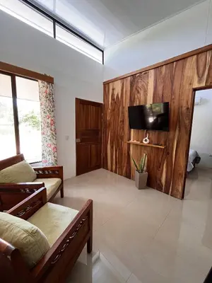 a living room with wooden walls and a flat screen tv at Accommodation in Tamarindo in Garita