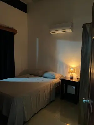 a bedroom with a bed and a table with a lamp at Accommodation in Tamarindo in Garita