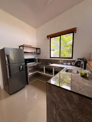 a kitchen with a stainless steel refrigerator and a window at Accommodation in Tamarindo in Garita