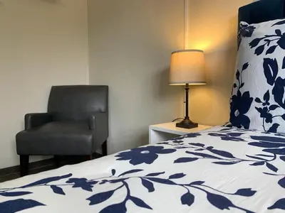 a bedroom with a bed and a chair and a lamp at Cata bed & breakfast 2026 in San José